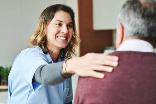 healthcare worker with a hand on a patients shoulder