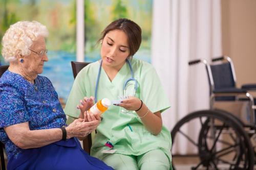 student assisting a patient with their medication