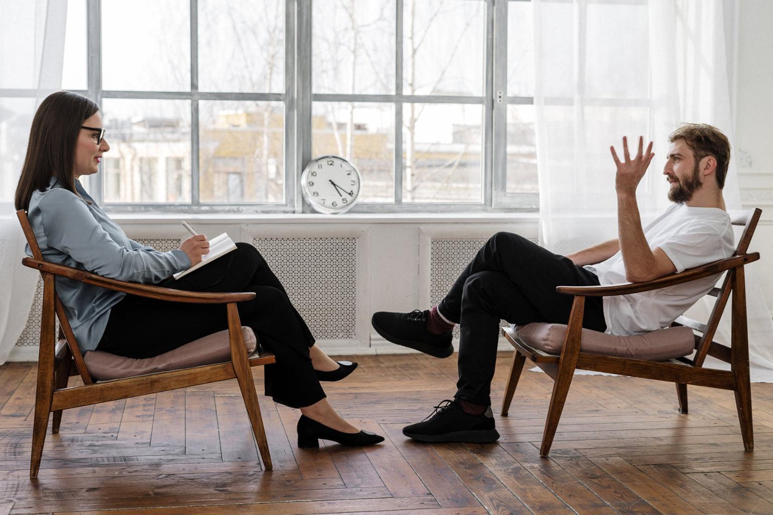 This photo shows two people sitting across from each other, talking
