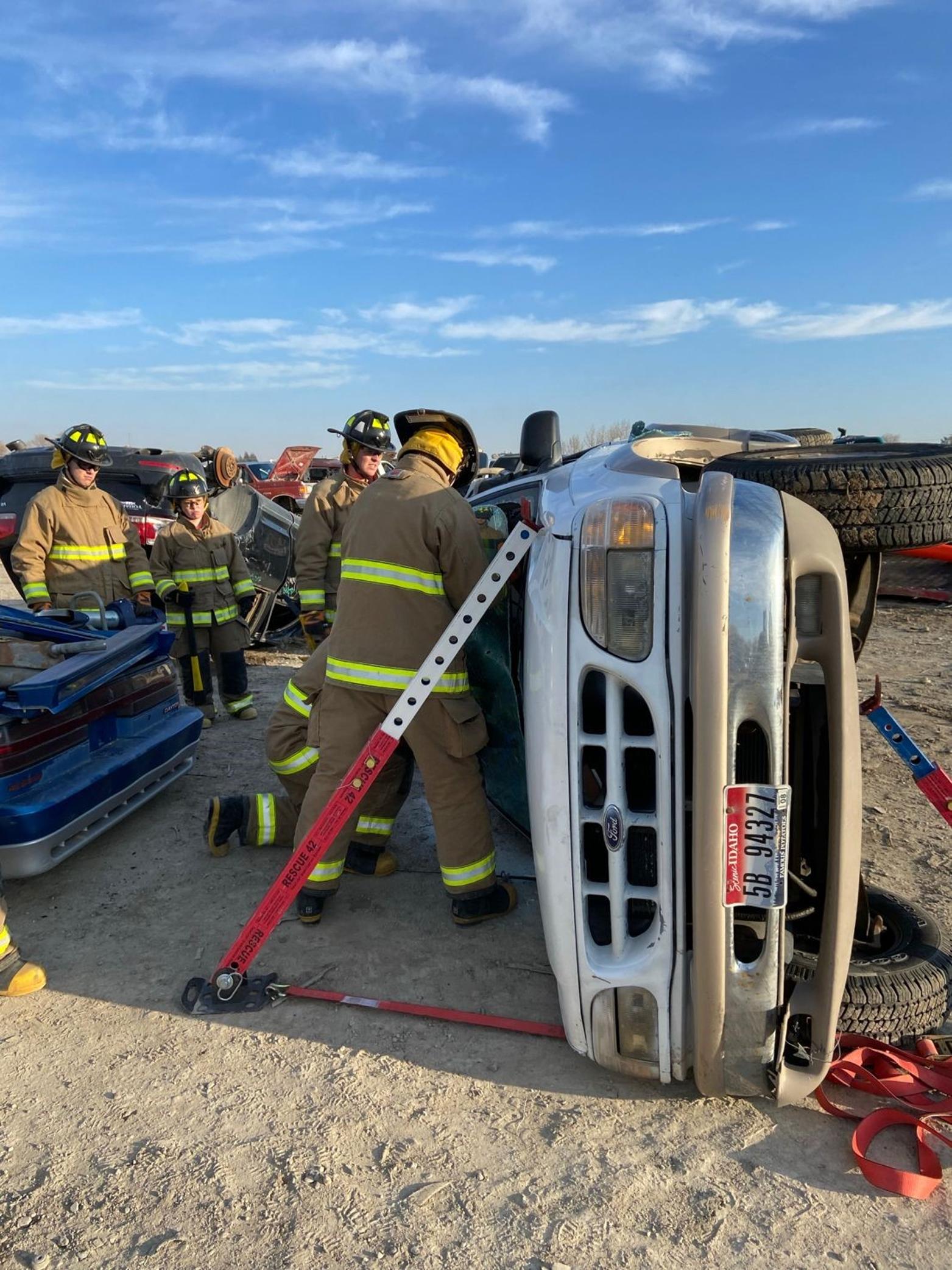 fire students use the jaws of life on a car during a training