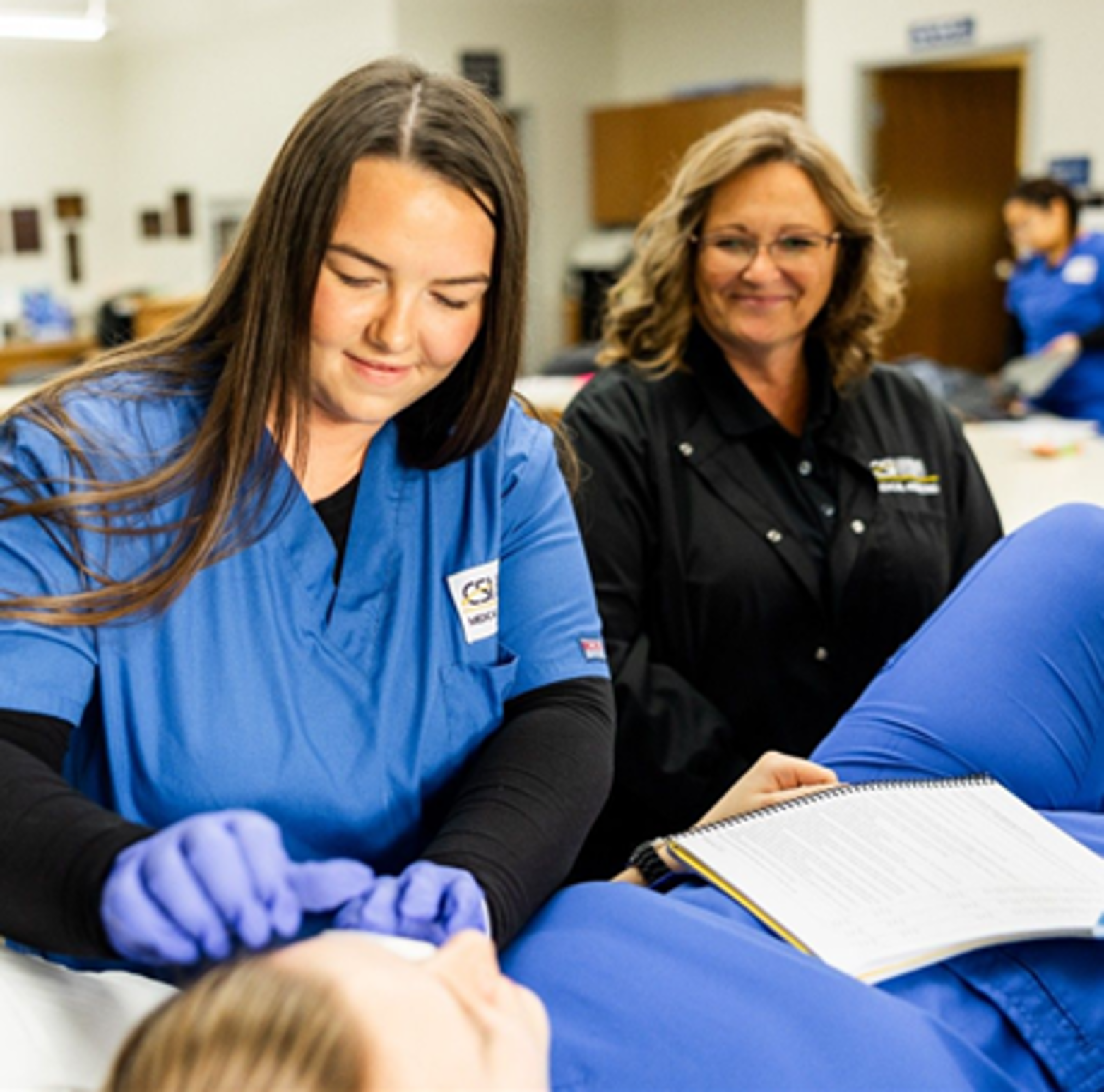 Program Manager, Kara Mahannah assisting her students as they practice their skills