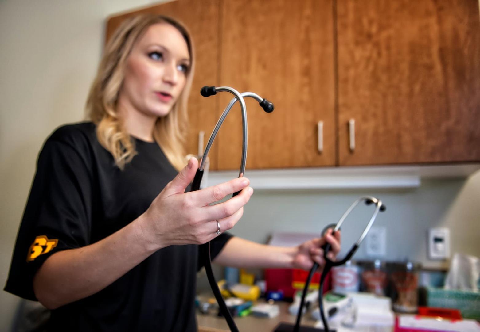 CNA student holding two stethoscopes